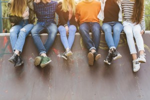teens sitting together on a wall